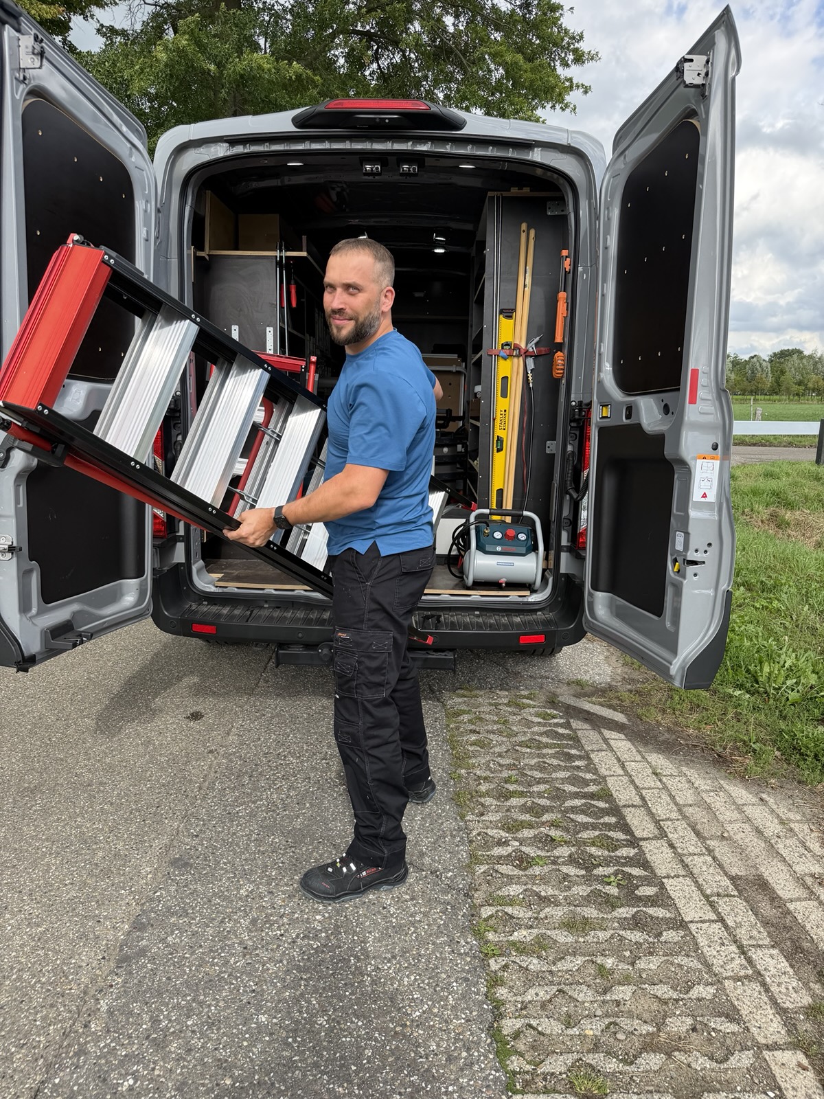 Rinze de Dreu haalt een ladder uit zijn bedrijfsbus